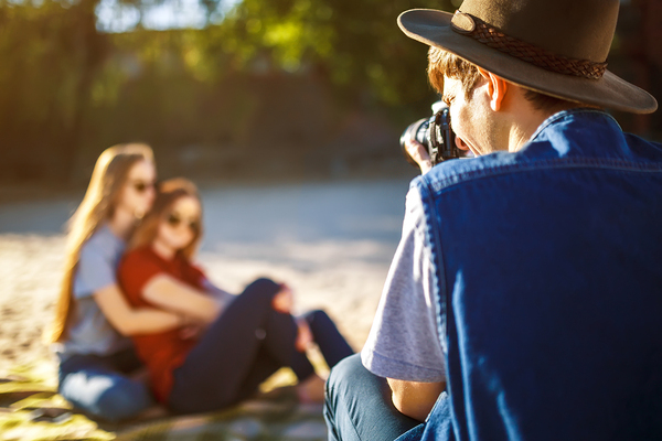 Group of friends enjoying time on beach. Laugh and smile. Friendly atmosphere. Guys enjoy photos.