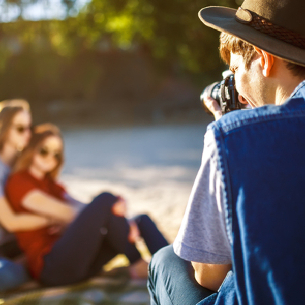 Group of friends enjoying time on beach. Laugh and smile. Friendly atmosphere. Guys enjoy photos.