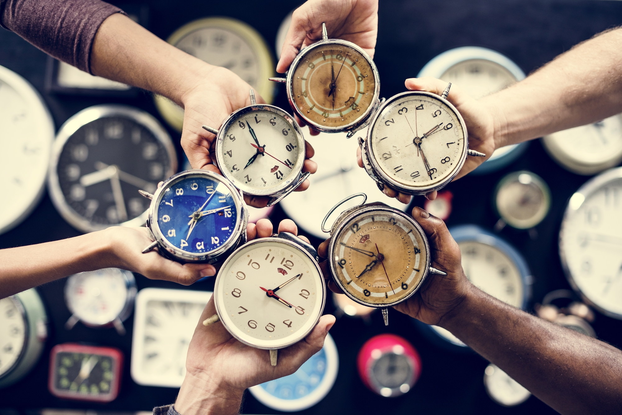 Hands holding clocks