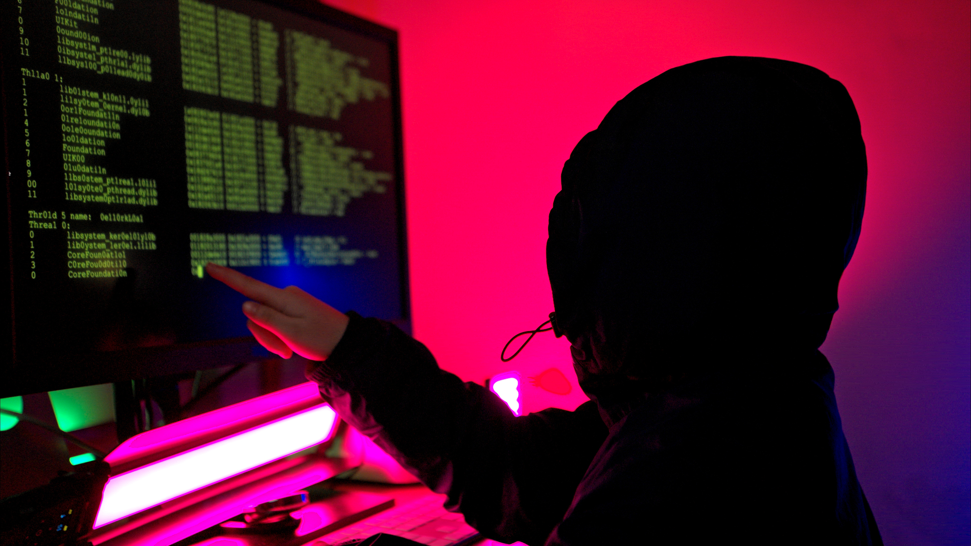 A boy wearing headsets and enjoying online gaming together in a neon lit room