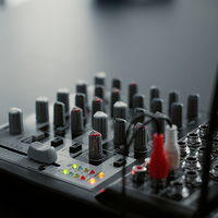 DJ mixer console with knobs and equalizer standing on home studio desk. Professional audio sound station electronic controller in living room video recording space. Close up